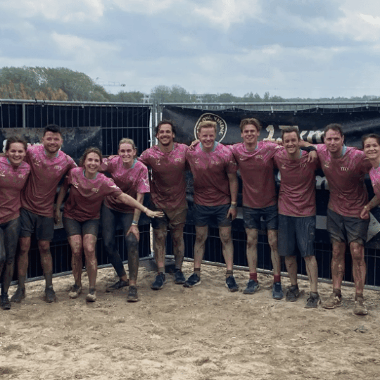Ten colleagues in pink My Jewellery shirts covered in mud during the Viking Run 2025.