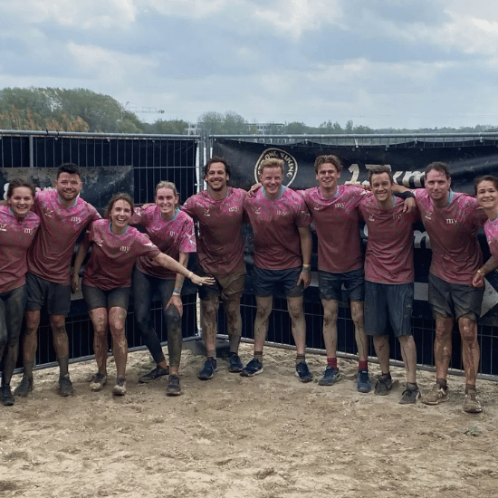 Tien collega's in roze My Jewellery shirts en onder de modder bij de Viking Run 2025.