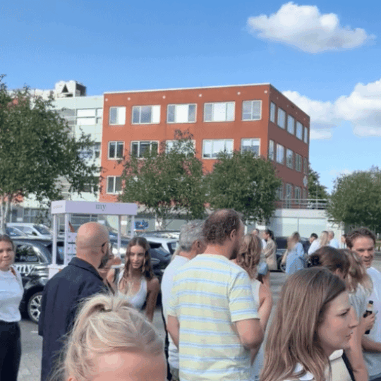 Colleagues standing outside the My Jewellery Headquarters in ’s-Hertogenbosch during the summer drinks event with a French fries food truck.