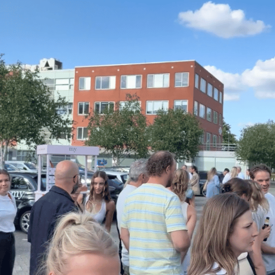 Collega's staan buiten bij het My Jewellery Hoofdkantoor in 's-Hertogenbosch op de zomerborrel met een frietkar