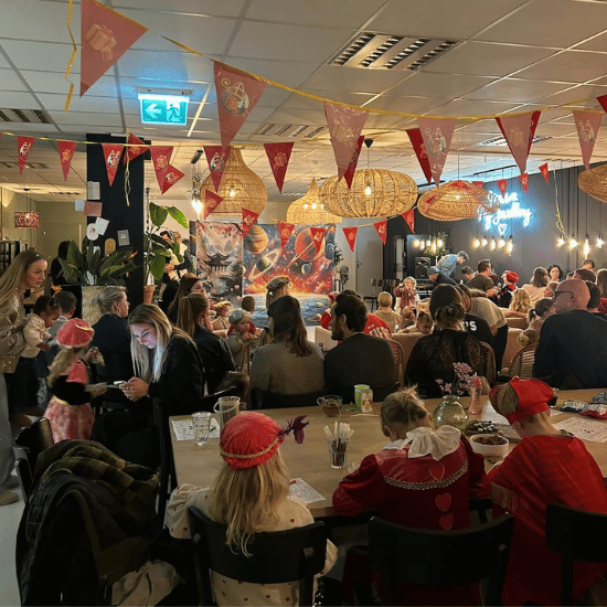 Collega's met hun kinderen op het My Jewellery Hoofdkantoor in 's-Hertogenbosch, aan het kijken naar een pietenshow met Sinterklaas