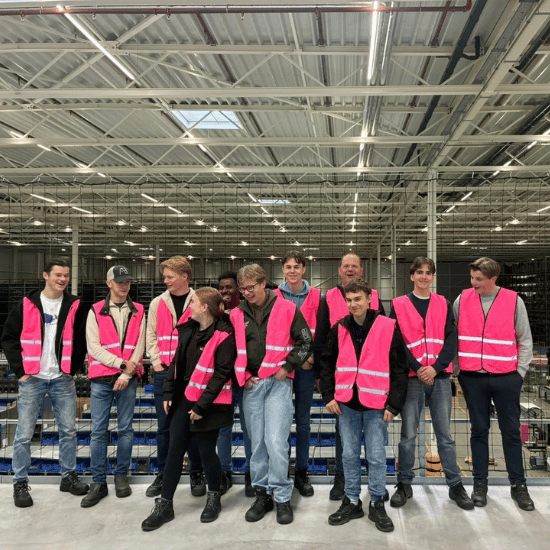 Studenten van het Koning Willem 1 College in 's-Hertogenbosch staan in My Warehouse met roze veiligheidshesjes aan