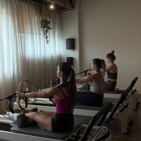 Drie collega's die een reformer pilates klas volgen in 's-Hertogenbosch