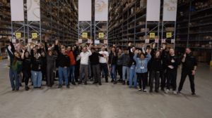 Teamfoto van My Warehouse van My Jewellery in 's-Hertogenbosch. Er staan tientallen mensen net hun handen omhoog voor een zestal stellingen