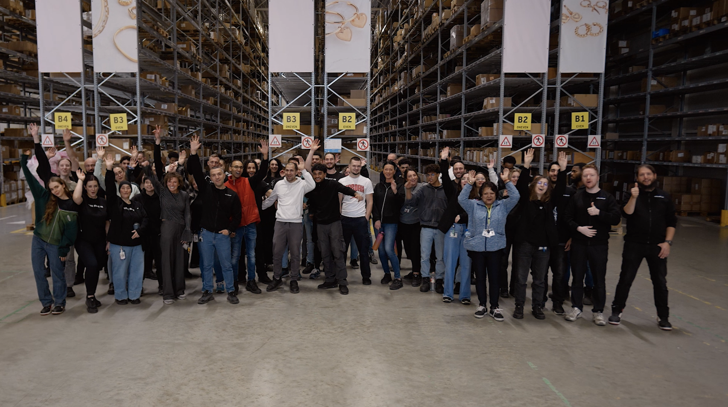 Teamfoto van My Warehouse van My Jewellery in 's-Hertogenbosch. Er staan tientallen mensen net hun handen omhoog voor een zestal stellingen