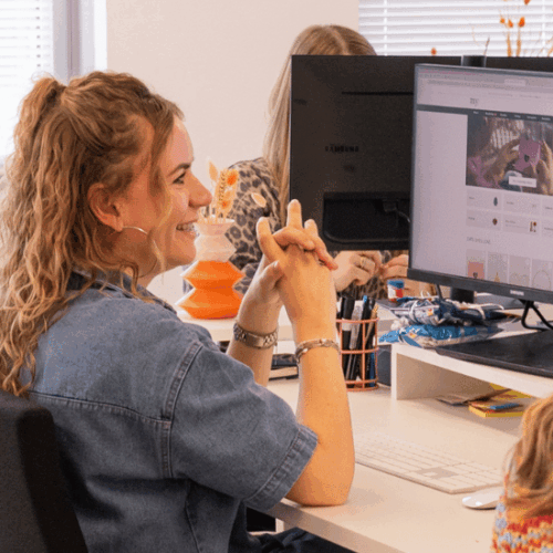 Lachende collega achter computer op het My Jewellery Hoofdkantoor in 's-Hertogenbosch