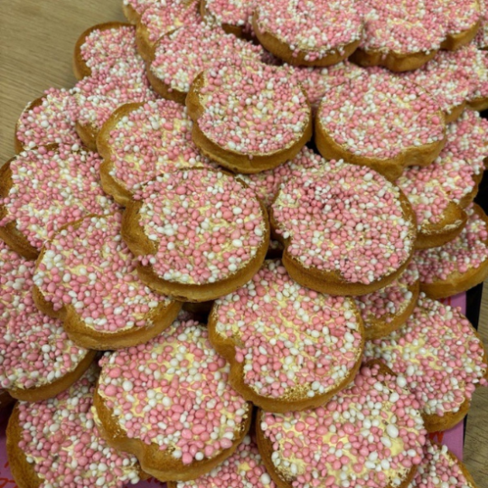 Un plateau rempli de biscottes saupoudrées de vermicelles roses pour fêter une naissance