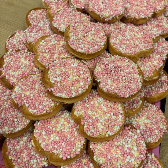 Un plateau rempli de biscottes saupoudrées de vermicelles roses pour fêter une naissance