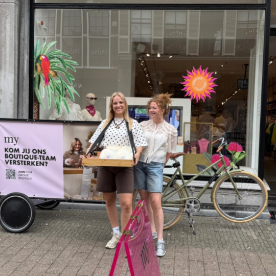 Zwei Kolleginnen verteilen bei einer Recruiting-Aktion vor der My Jewellery Boutique in Zwolle Stroopwafeln.